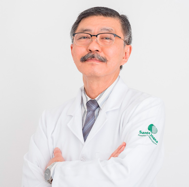 Foto do Dr. Mário Macoto Kondo, um homem asiático de óculos, cabelos e bigode pretos